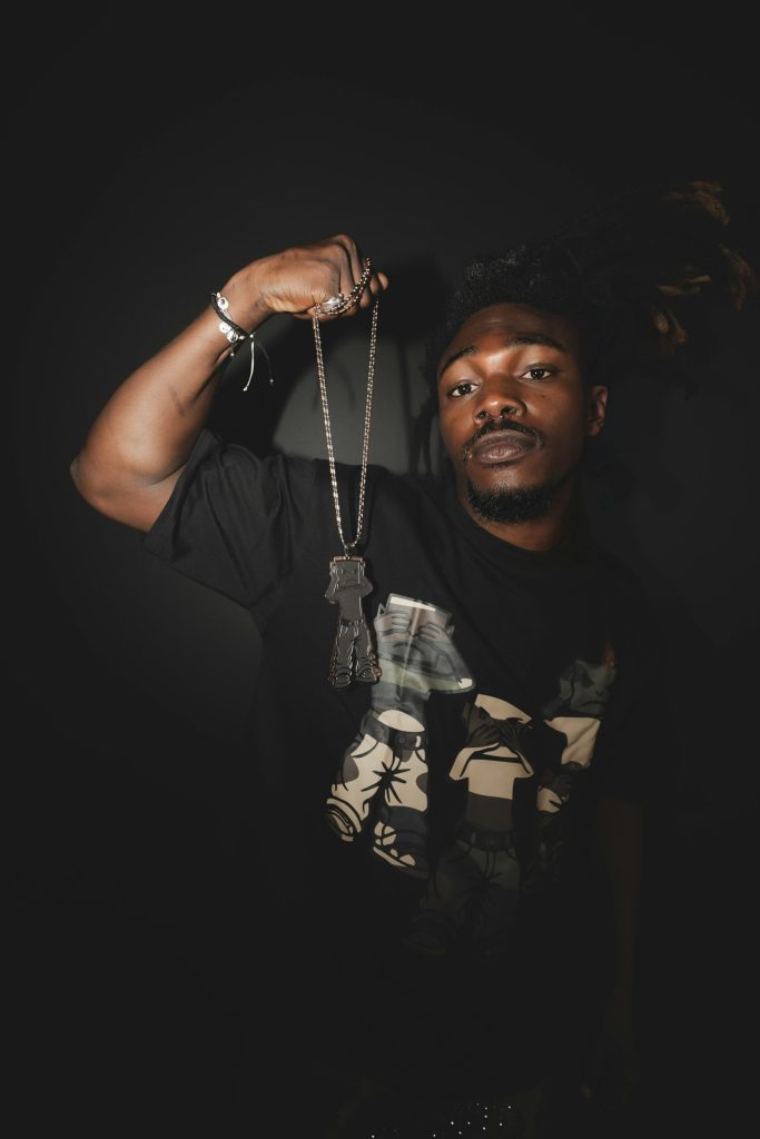 Silver chain held against a dark background